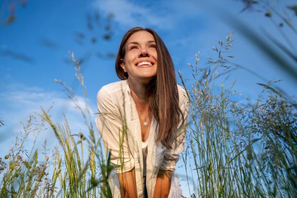 Low angle view portrait of a woman standing in the meadow Healthy Ways to Spend Your Free Time