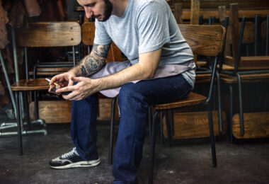 How High-Functioning Addiction Hides in Successful Men Man sitting using mobile phone on the chair
