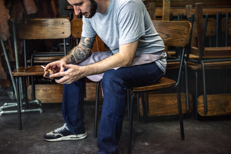 How High-Functioning Addiction Hides in Successful Men Man sitting using mobile phone on the chair